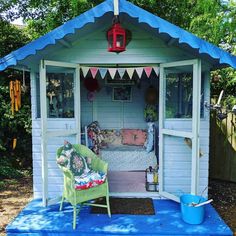 a blue shed with a green chair in it