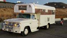 an old white truck with a camper on the back