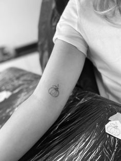 a black and white photo of a person's arm with a tattoo on it