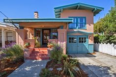 a pink house with blue trim and green roof