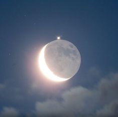 the moon is in the sky with clouds around it