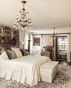 a bedroom with a large bed and chandelier hanging from it's ceiling