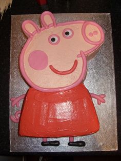 a cake shaped like peppa pig sitting on top of a table