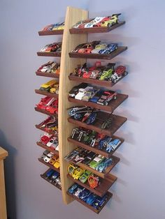 a wooden boat shaped shelf filled with toy cars