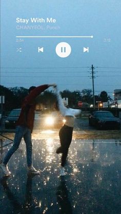 two people dancing in the rain at night