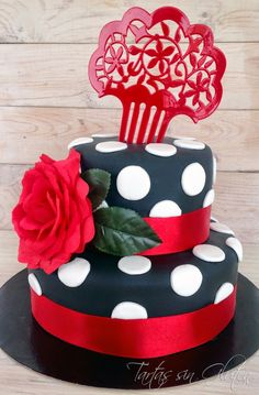 a polka dot cake with a red rose on top