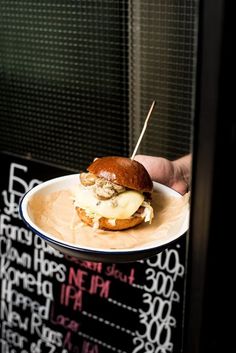 a person holding a plate with a sandwich on it