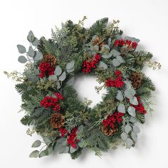 a christmas wreath with red berries and greenery