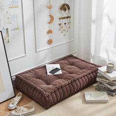 a brown dog bed sitting on top of a wooden floor next to a pair of shoes