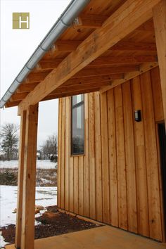 the side of a wooden building with a metal roof