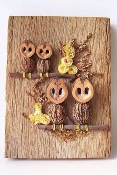 three owls are sitting on a branch with flowers in the center and two smaller ones behind them