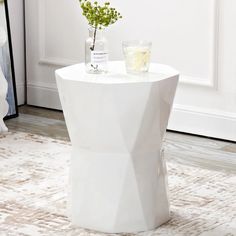 a white table with a vase on it