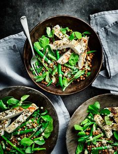 two bowls filled with green vegetables on top of a table