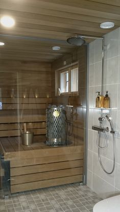 a bathroom with a wooden sauna and tiled flooring in the shower stall area