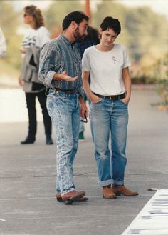 two men walking down the street talking to each other