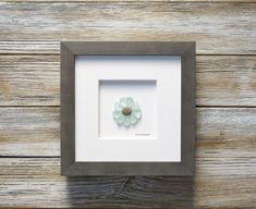 a white and gray frame with a flower in it