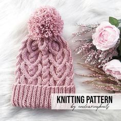 a pink knitted hat next to flowers on a white furnishing with text overlay that says knitting pattern