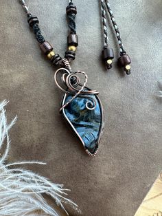 Embrace the mystical energy of Pietersite with this handmade pendant in antiqued copper. This bohemian necklace features a macrame detail for a unique touch. Perfect for those who love artisan jewelry. This pendant is wire wrapped and hand woven in solid copper with a Pietersite Cabochon and then oxidized and hand polished to give that antiqued look. ★★Material and size★★ Pendant size approx :  54x24mm (Pietersite approx 31x21mm) Waxed Polyester threads, wood bead , brass bead, coconut shell bea Bohemian Hand Wrapped Pendant Jewelry, Handmade Bohemian Copper Wire Jewelry, Earthy Wire Wrapped Jewelry For Festivals, Bohemian Hand Forged Necklaces For Festivals, Bohemian Hand Forged Necklace As Gift, Earthy Pendant Jewelry For Festival, Earthy Copper Jewelry For Festivals, Artisan Labradorite Necklaces For Festivals, Bohemian Hand Forged Adjustable Jewelry