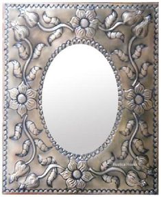 a decorative mirror with flowers and leaves on it