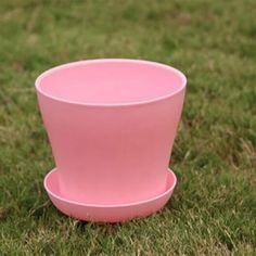 a pink cup sitting on top of a green field