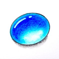 a blue glass object sitting on top of a white surface