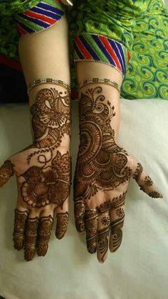 two hands with henna designs on them