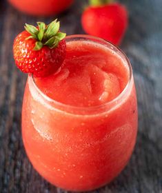 a close up of a drink in a glass with a strawberry on top