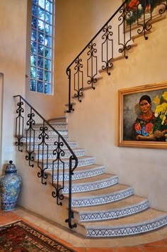 the stairs are decorated with blue and white tiles, along with a painting on the wall