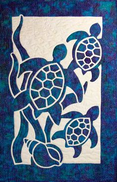 a quilted wall hanging with two sea turtles on it's sides and one turtle in the middle