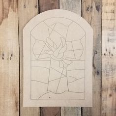 a piece of paper with a stained glass window in it on a wooden wall next to wood planks