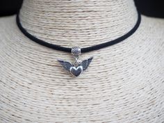 "Heart with Wings Necklace Winged Heart Pendant Cord Choker Vegan Necklace Angel Wings Choker Black Suede Necklace Unisex Necklace ~ A boho necklace with metal pendant. ~ Black colour cord, 12\" shortest length. ~ Clasp and 2\" extender chain to adjust to you. ~ Made with the utmost care to enjoy it as long as possible. All jewelries are are in stock and ready to be shipped within 1-2 business day from ordering to dispatch. Please note these times increase during Christmas & busy periods. 🌍 SHI Heart-shaped Metal Necklaces For Festivals, Heart-shaped Metal Necklace For Festival, Silver Heart Choker For Festivals, Heart-shaped Silver Choker For Festivals, Suede Necklace, Cord Choker, Winged Heart, Wings Necklace, Choker Black