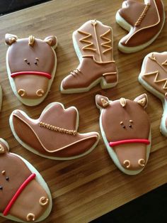 decorated cookies with cowboy hats and boots are on a table next to other cookies that have been cut into the shape of horses