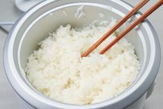 two chopsticks sticking out of rice in a pot