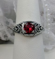 Simulated or Natural (1.3ctw) Red Ruby Ring Valentine Design#211 Custom Made This is a stunning Edwardian style, Victorian wedding reproduction gemstone filigree ring. The simulated or natural round cut ruby red gemstone is 6mm in diameter. This lovely solid sterling silver ring is marked 925 for sterling silver. The ruby is heat and color treated and is i1 - i3. Perfect to show someone how much you care about them, this ring is even etched with the word "love" on each side.  There is beautiful Red Jewelry With Center Stone Round Band, Red Jewelry With Center Stone In Round Band, Classic Red Jewelry With Lab-created Ruby, Classic Red Lab-created Ruby Jewelry, Red Jewelry With Accent Stones And Round Band, Red Brilliant Cut Rings For Wedding, Red Round Cut Jewelry With Center Stone, Red Brilliant Cut Wedding Rings, Classic Red Jewelry With Round Cut