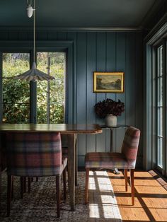 a dining room with blue walls and plaid chairs