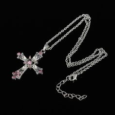 This lovely piece is the timeless cross with pink, purple, and clear crystal gems embedded all over the silver base. The pendant from Innovato Design comes with a silver chain that can be as long as 50cm. The pendant is actually of petite size, measuring 34x44mm. It comes in a cute rectangular box, cushioned with a lovely black felt lining. This pretty accessory serves as a great gift for a friend, lover, or relative; but is also a wonderful little accessory to keep for yourself. At the center of the cross lays a tiny heart-shaped mold, where a large pink crystal is set.  Surrounding the heart are tiny pink crystals that further accentuate this lovely detail.  Product Highlights:    Durable Stainless Steel Material Used  Lovely Cross Design with Beautiful Crystals  20" Long link chain incl Pink Sterling Silver Cross Jewelry, Crystal Cross Pendant Necklace With Bling, Pink Cross Necklace, Purple Cross Necklace, Purple Love Heart, Purple Amethyst Cross Necklace, Necklaces Aesthetic, Pink Sterling Silver Pendant Crystal Necklace, Holiday Necklace