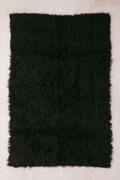 a black area rug on top of a white floor