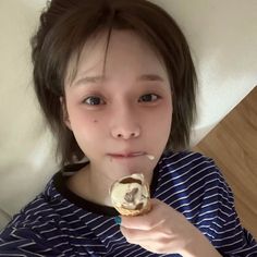 a young woman is eating an ice cream sandwich