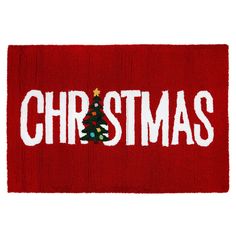 a red door mat with the word christmas written on it and a small tree in the center