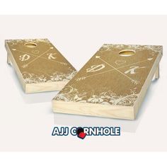 two cornhole game boards with gold and white designs on the top, one is made out of wood