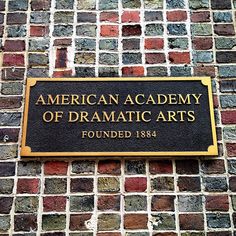 an american academy of dramatic arts plaque on a brick wall