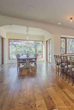 a large dining room with wooden floors and lots of windows