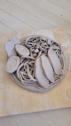 a bowl that is sitting on top of a wooden table with some kind of clay