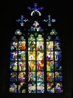 a very large stained glass window in a dark room