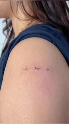 the back of a woman's shoulder with an arrow tattoo on her left arm