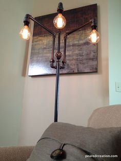 a lamp that is on top of a couch in front of a wall mounted painting