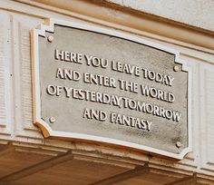 a plaque on the side of a building that says here you leave today and enter the world of yesterday tomorrow and fantasy