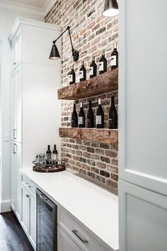 a brick wall in a kitchen with bottles on the shelves