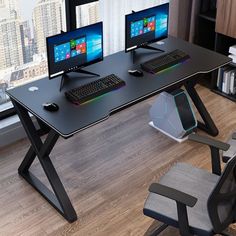 two computer monitors sitting on top of a black desk