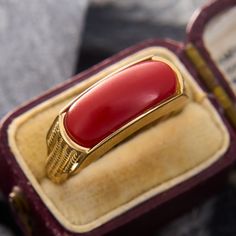 This pop of color ring features a rectangular orangey-red coral saddle. The shoulders of the ring are accented by vertical rope twists of gold. The ring is crafted in 14k yellow gold and is currently a size 7.25.  Jewelers epoxy helps secure the coral. Heirloom Red Gold Signet Ring, Elegant Red 14k Gold Signet Ring, Art Deco Red Rectangular Jewelry, Red Rectangular Art Deco Jewelry, Red Rectangular 14k Gold Jewelry, Red Rectangular 14k Gold Ring, Rectangular Red 14k Gold Jewelry, Rope Twists, Red Coral Ring